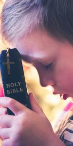 A boy holding a bible
