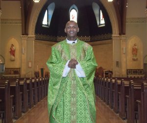 A vested Priest stands in a church