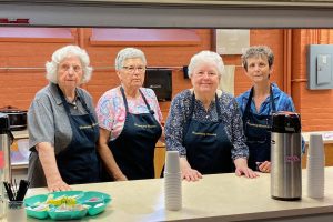 Hospitality team members stand at the counter in the kitchen.