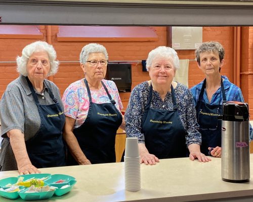 Hospitality team members stand at the counter in the kitchen.