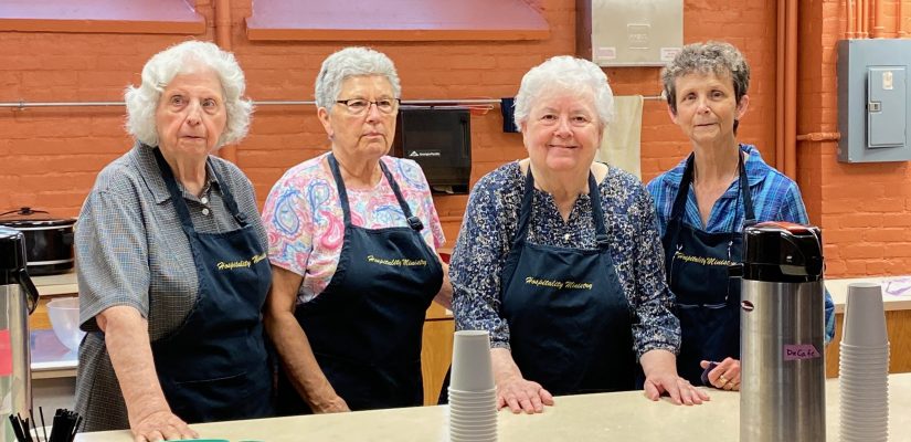 Hospitality team members stand at the counter in the kitchen.