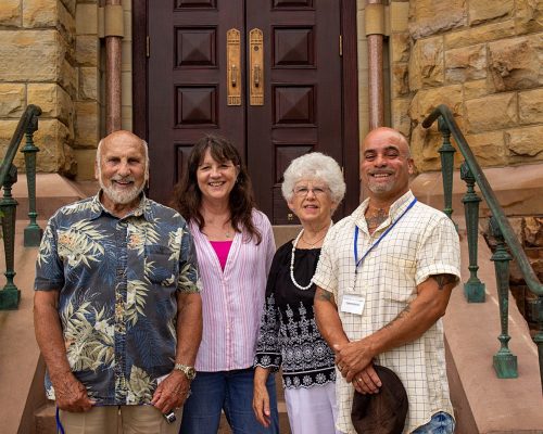 2 women and 2 men stand at the bottom of the church steps