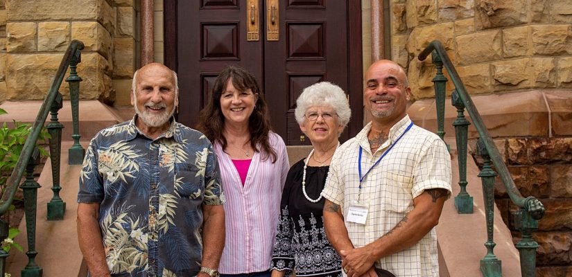 2 women and 2 men stand at the bottom of the church steps