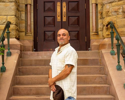 A man stands at the bottom of church steps