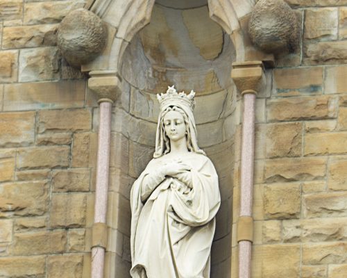 statue of the Virgin Mary in the stone wall of a church