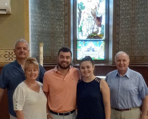 A family of 5 people stand together in a church