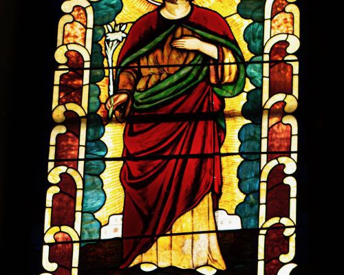 Stained glass window of Saint. Donated by John Dempsey in memory of Dennis Dempsey.