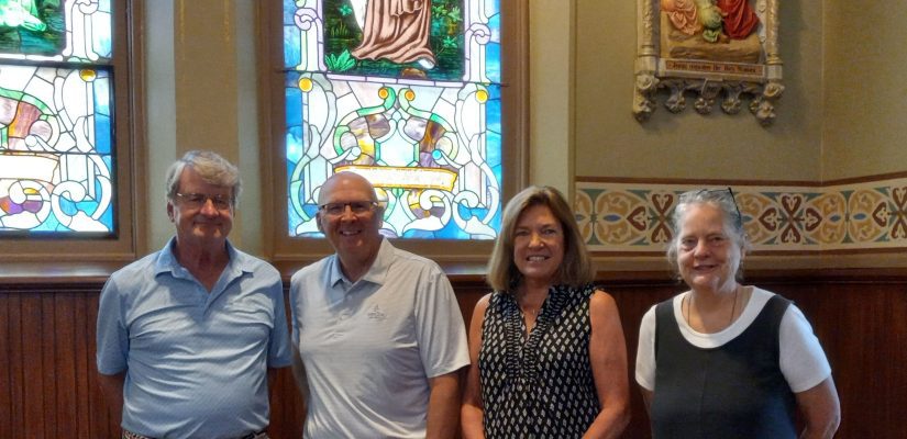 2 men and 2 women stand in a church