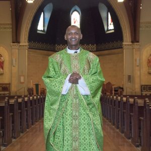 A vested Priest stands in a church