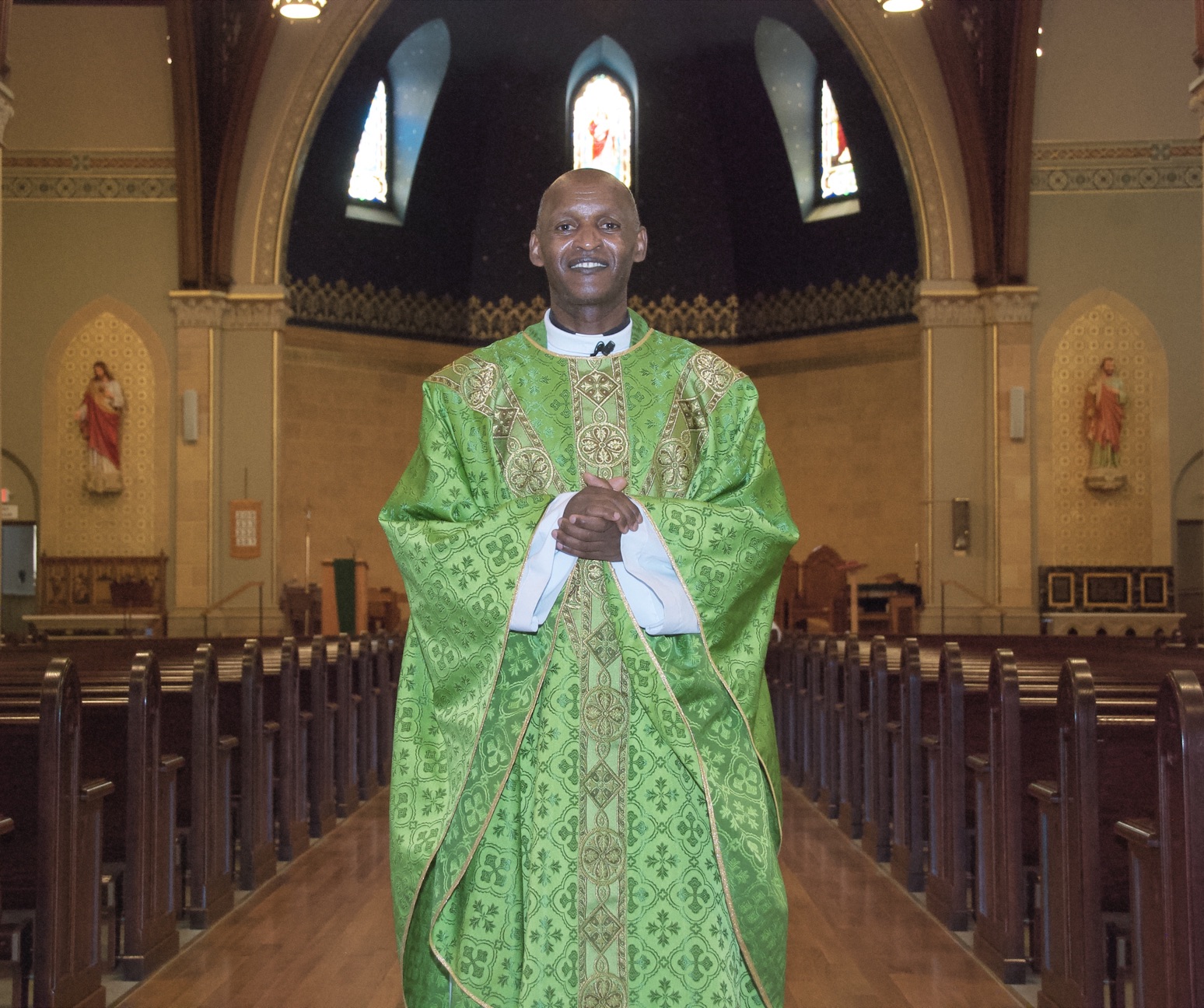 A vested Priest stands in a church