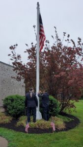 Members of the VFW Post 961 Color Guard prepare to lower the flag to half-staff at the annual Memorial Day Ceremony at Calvary Cemetery.
