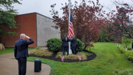 Members of the VFW Post 961 Color Guard lower the flag to half-staff at the annual Memorial Day Ceremony at Calvary Cemetery. Senior Vice-Commander Dan Weed proudly salutes as members of the parish community and public (not-shown) look on.